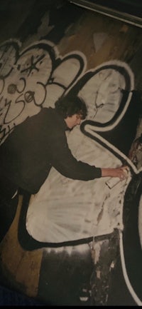 a photo of a man painting graffiti on a wall